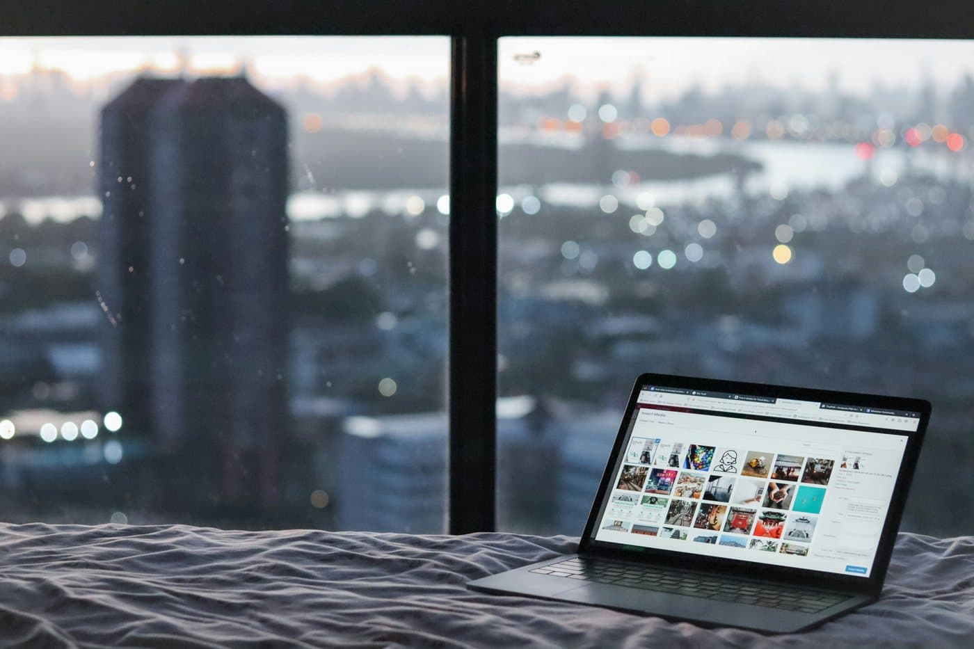 Working on a laptop by a window overlooking Osaka